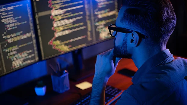 Webdesigner am Arbeitsplatz mit Code-Editor, Agentur PRO2 New Media in Oberösterreich – nachhaltiges Webdesign.