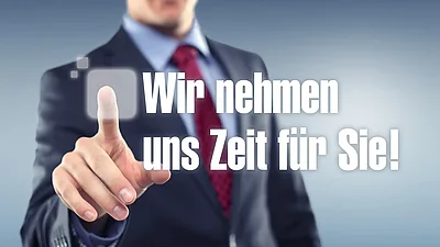 Mann zeigt auf den Schriftzug "Wir nehmen uns Zeit für Sie!" auf einer transparenten Glasfront.